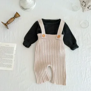 Baby gebreide tuinbroek set met zwarte trui en beige bretelbroek voor hippe stijlen.
