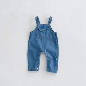 Infant denim overalls detail shot, classic blue baby jumpsuit with front pocket and snap buttons.