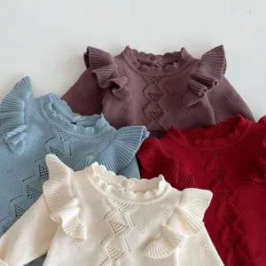 Cute baby knit sweater detail showcasing ruffled shoulders, hollow-out texture, soft fabric.