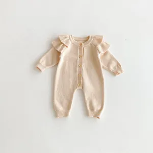 Adorable baby knitted romper detail, featuring cute ruffles and wooden buttons for cozy autumn.