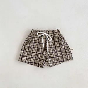 Vue détaillée de short décontracté à carreaux pour tout-petit avec cordon de serrage blanc.