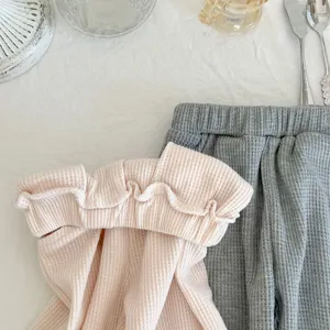Waffle knit toddler clothing detail, cute pink sweatshirt and grey pants set for kids.