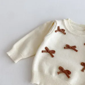 Dettaglio maglione in maglia bimba, grazioso fiocco marrone, scollo rotondo morbido top.