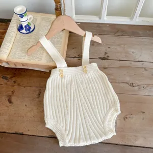 Süßes Detail des gerippten Babystramplers mit Holzknöpfen und weicher Strickqualität.