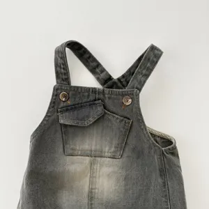 Infant washed denim overalls detail shot, cute baby romper with front pocket and cross straps.