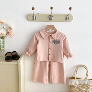 Details des rosa Mädchen Langarmshirts und Hosen Sets mit süßem Puppenkragen und Karotasche.