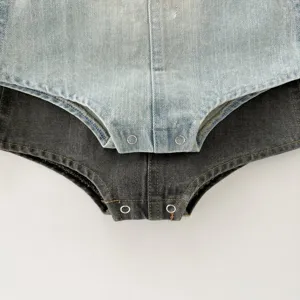 Infant denim romper detail view, soft fabric with snap buttons, classic baby clothing design.