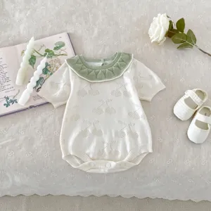Detailed view of summer knitted baby girl romper featuring a green doll collar and sweet cherry pattern.