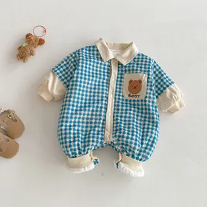 Detail shot of baby winter romper, blue plaid fabric, cute bear pocket and soft lapel.