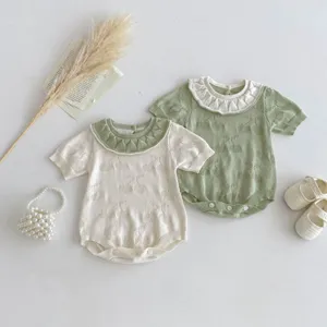Detail shot of summer baby knitted doll collar romper with cute hollow cherry pattern and ruffles.
