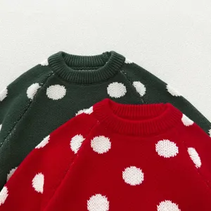 Detailed view of cute toddler girls knit sweater with white polka dots and cozy wool texture.
