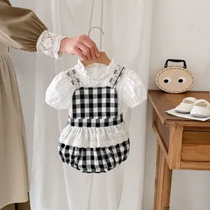 Cute baby girl summer outfit with checkered romper and white blouse set for toddlers.