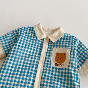 Detailed view of the baby winter fleece padded romper, blue plaid with cute bear pocket.