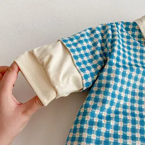 Baby thermal padded jumpsuit detail view showing blue plaid fabric and ribbed cuffs.