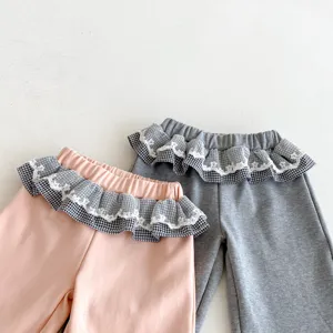 Detailansicht süßer Kleinkind-Mädchenhosen mit Rüschenbund und Karomuster-Spitzenbesatz.
