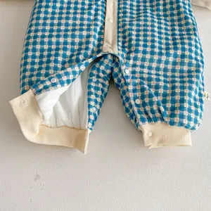 Baby winter fleece-lined romper detail in blue plaid with cozy snap buttons and warm padding.