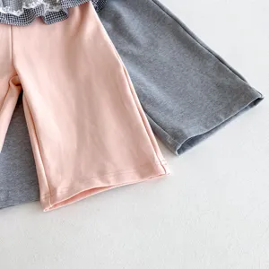 Kinder Schlaghose Detailaufnahme, rosa und graue Hosen mit kariertem Kragen Design neu.