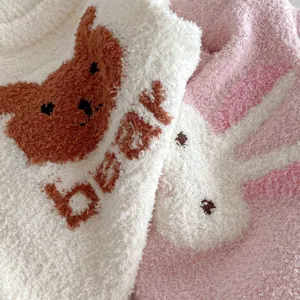 Close-up detail of soft fuzzy baby romper fabric with cute bear and rabbit plush patterns.