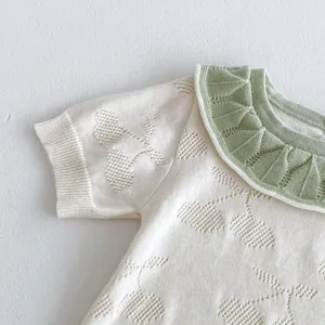 Baby knit romper detail shot showing doll collar and hollow-out pointelle pattern.