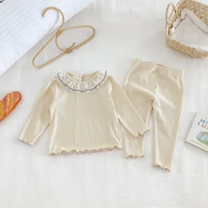 Detail of baby girl ribbed long sleeve top and pants set with delicate lace collar.