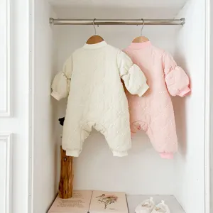 Cute baby padded jumpsuit for winter, cozy long sleeve cotton romper in pink and off-white.