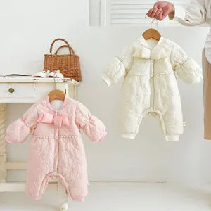 Cozy winter baby romper detail shot featuring quilted design and sweet bow decoration for girls.