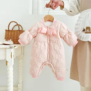 Detailed view of a cute pink quilted baby romper featuring a lovely bow and warm lining for winter.