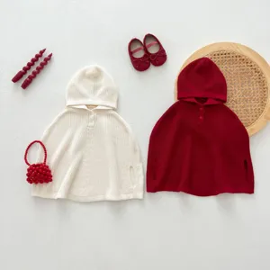 Vista detallada de lindas capas con capucha de punto para bebé en beige y rojo con accesorios.