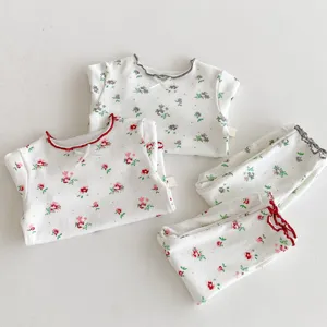 Kids floral pajama set detail view, soft cotton long sleeve top and pants with lettuce trim.