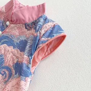 Girls Chinese style cheongsam dress detail, pink collar and wave pattern fabric close up.
