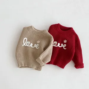 Detailed shot of toddler knit sweater with cute letter embroidery and soft warm fabric.