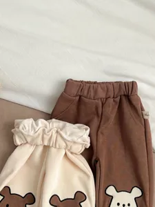 Gedetailleerd overzicht van schattige peuterbroek met berenborduurwerk en elastische taille.