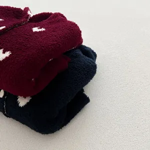 Lindo capa con capucha de lana de invierno para bebé niña ropa de felpa suave apilada ordenadamente.