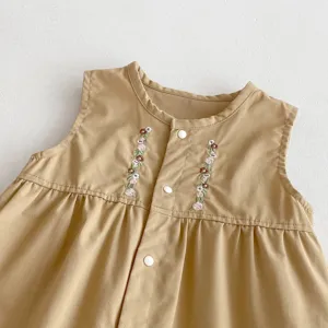 Nahaufnahme der ärmellosen khaki Baby Strampler Details mit feiner floraler Stickerei.