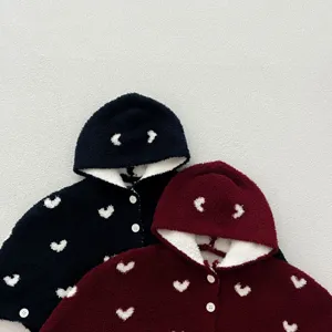 Vista detallada de la capa con capucha de forro polar para bebés con corazones.
