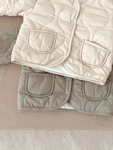 Detailansicht der wattierten Baby Winterjacke mit Druckknöpfen und weichem warmen Stoff.