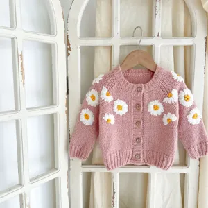 Infant baby knitted cardigan sweater detail view featuring cute handmade daisy embroidery.