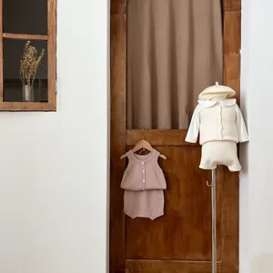 Vue detaillee d'un ensemble de gilet et short en tricot pour bebe style vintage.