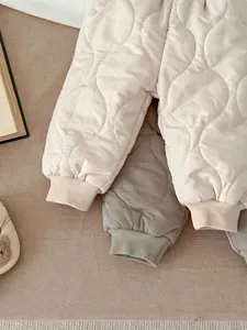 Nahaufnahme der gesteppten Babymantelhose, warm wattiertes Design mit kuscheligen Bündchen.