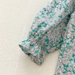 Gros plan sur le détail de manche florale pour fille, joli design bouffant avec poignet élastique.