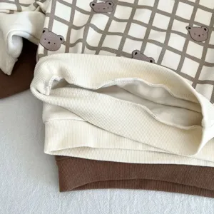 Detalle de sudadera para bebé con bonito estampado de oso y suave dobladillo.