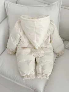 Detailansicht des gefütterten Baby Winter Overalls mit feiner Spitzenstickerei und Schleife.