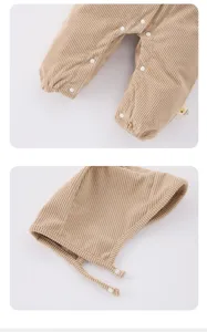 Gedetailleerd overzicht van baby ribfluwelen romper en bijpassend mutsje, fijne drukknopen.