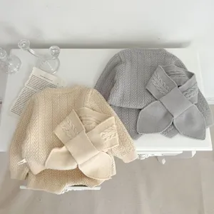 Vista detallada del tierno conjunto de suéter de punto para bebé con bufanda a juego.