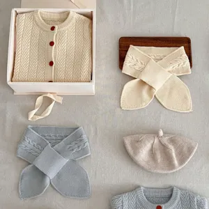 Detalle del conjunto de punto para bebé con cárdigan de punto, bufanda acogedora y linda boina.