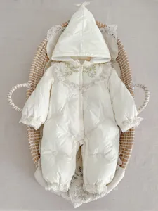 Detailansicht des weichen Baby Winter Schneeanzugs in Elfenbein mit feiner Blumenstickerei.