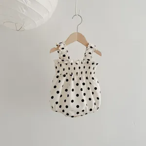 Gedetailleerd overzicht van een schattige baby meisje zomer stip romper met ruffles en bandjes.