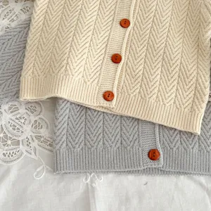 Detalle de cárdigan de punto para bebé, suéter de invierno suave para infantes con botones.