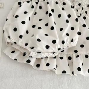 Gedetailleerde opname van schattige baby polkadot romper jurk met ruches voor zomer.