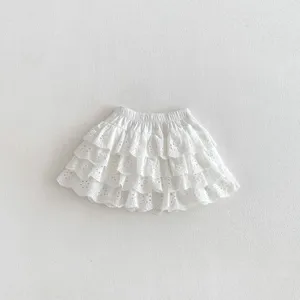 Detail view of a white eyelet lace tiered toddler skirt with elastic waist for summer.